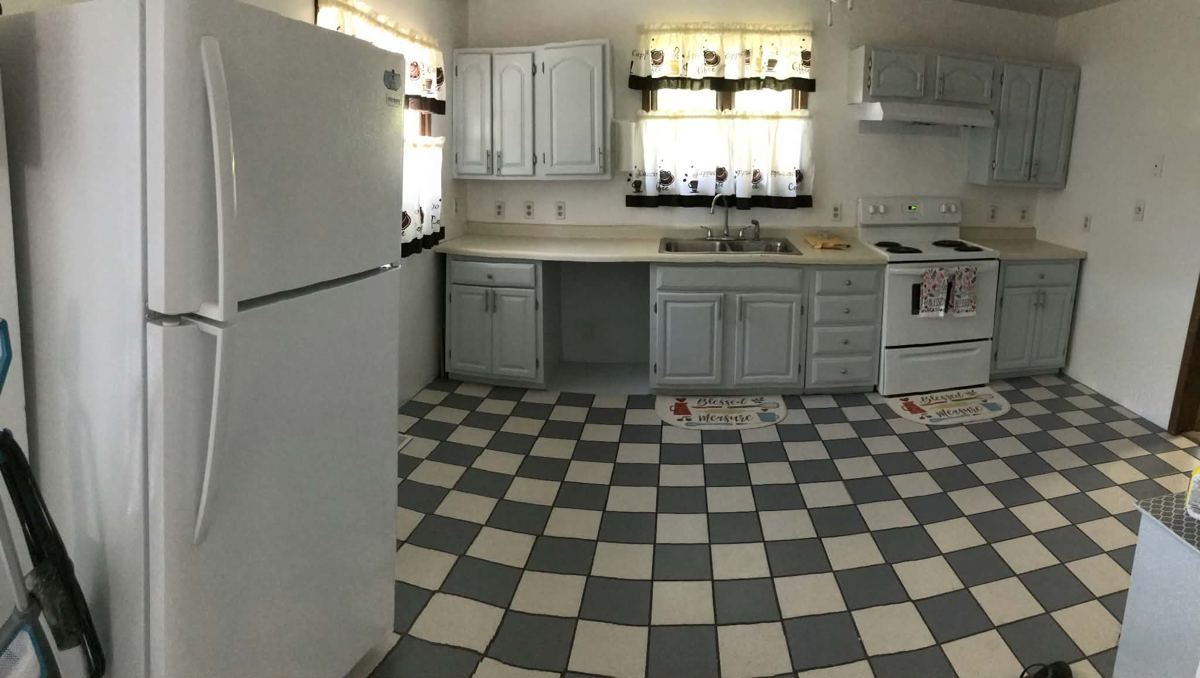 Finished kitchen with repainted grey cabinets and chequerboard floor