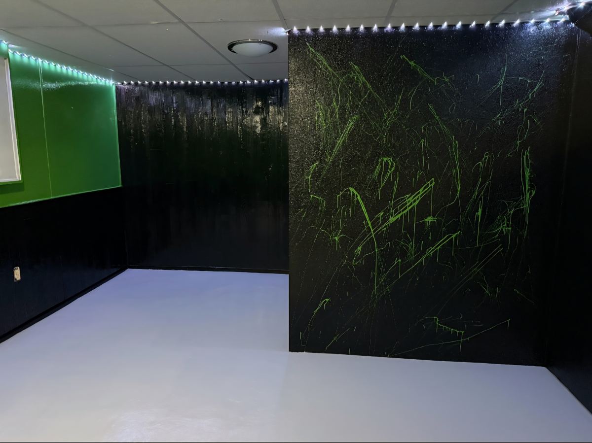 Finished basement game room with green and black walls and LED lighting